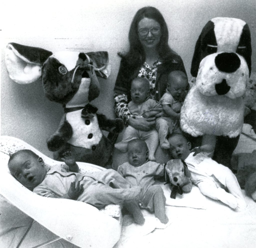 Debbie Davis is surrounded by her five babies and two of the large stuffed animals the family received as birth gifts.