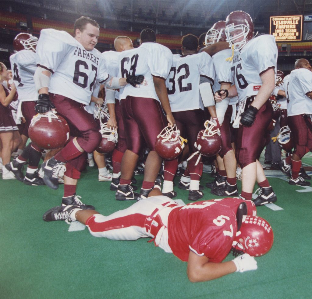 Houston Post photo by Adrees Batif, taken 12/18/1993. Caption: "MacArthur High School guard Shadrick Georg (57) lies on the field seconds after Lewisville High School won the 5-A Division II Championship Saturday afternoon in the Astrodome. First state football championship in school history; LHS defeated Aldine MacArthur, 43-37, in the Astrodome to complete a 15-0-1 season.